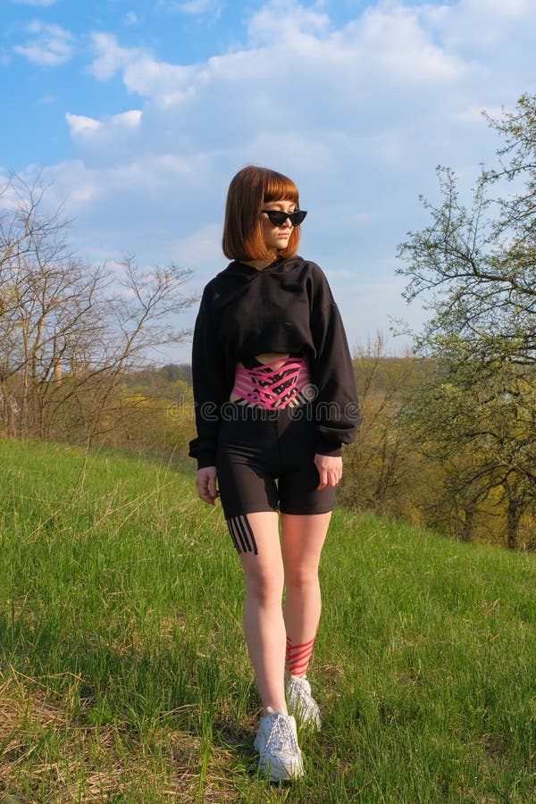 Young white girl with kinesio tape on her belly and legs outdoors in spring. Rehabilitation of Alternative Medicine stock photography Young white girl with kinesio tape on her belly and legs outdoors in spring. Rehabilitation of Alternative Medicine stock photography