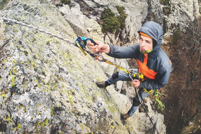 Young white man climbing a steep wall in the mountains, climbing extreme sports, wide angle Horizontal orientation stock photos Young white man climbing a steep wall in the mountains, climbing extreme sports, wide angle Horizontal orientation stock photos