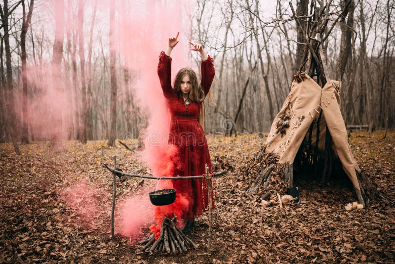 Young witch in the autumn forest