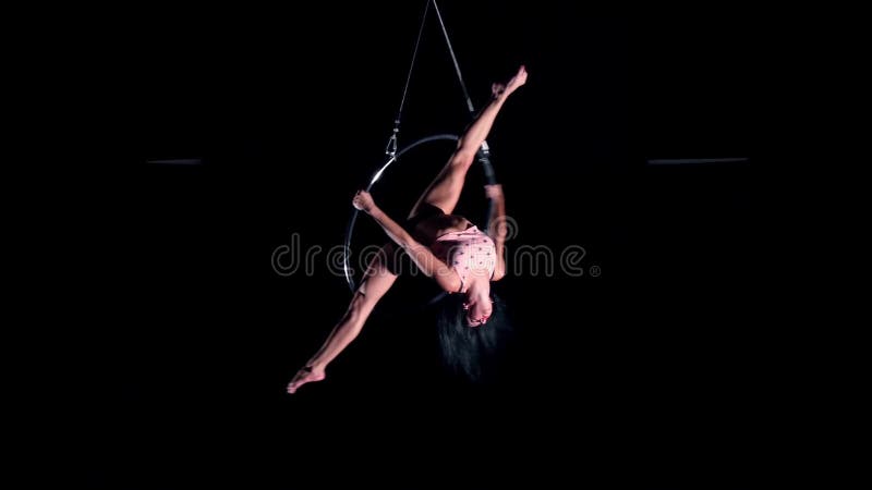 Young woman air gymnast on black background