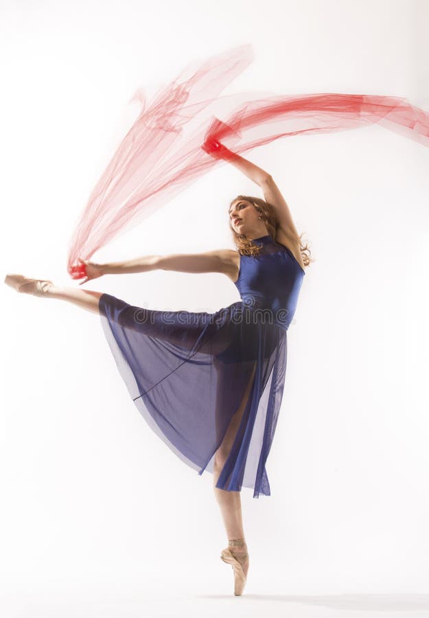 Young woman ballet dancer in pointe shoes,blue leotard and skirt, dancing in the studio with a red fabric, all against a white background. Young woman ballet dancer in pointe shoes,blue leotard and skirt, dancing in the studio with a red fabric, all against a white background