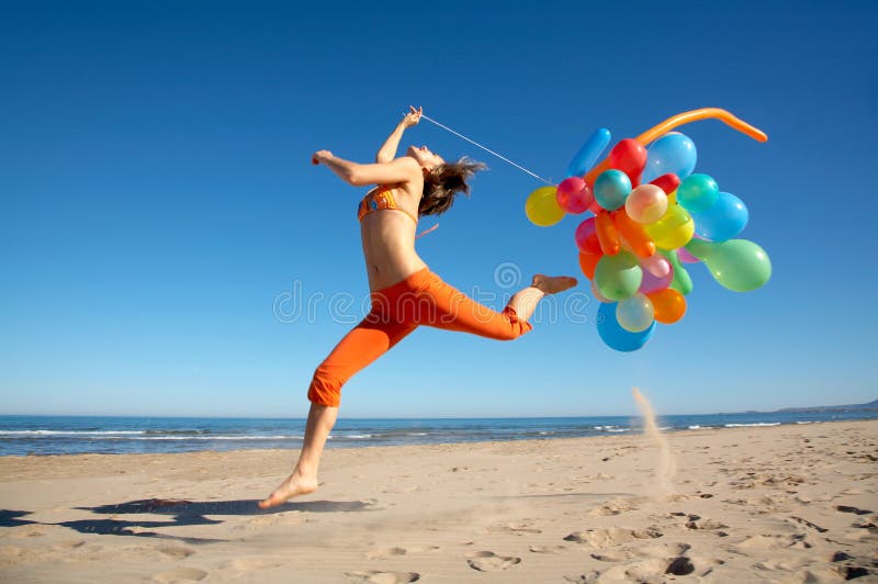 Young woman with balloons jumping