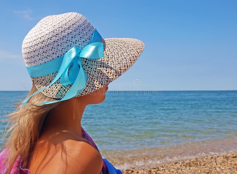 Young woman on a beach in a straw hat