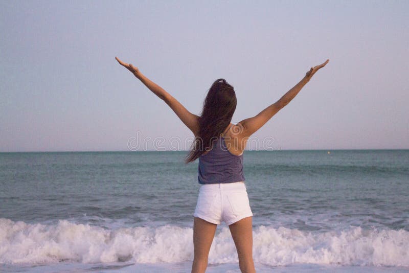 Young woman on the beach in very positive and happy attitude