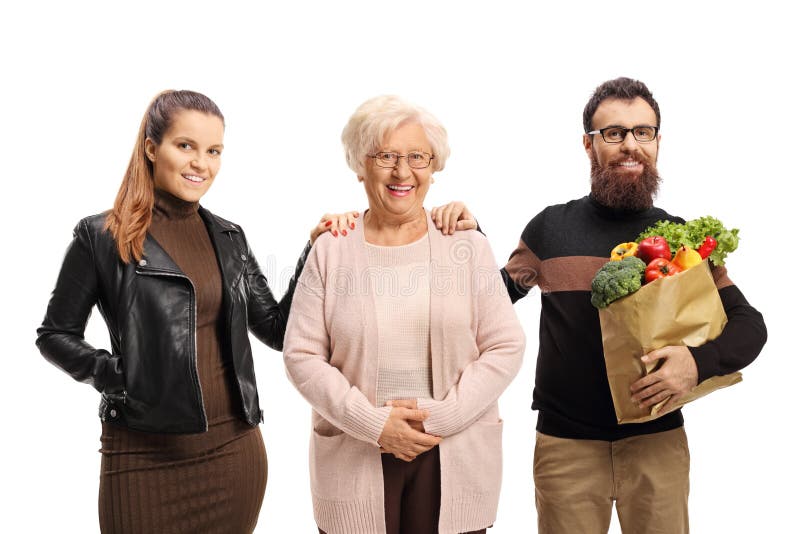 Young woman and a bearded man with fruits and vegetables in a paper bag helping an elderly woman