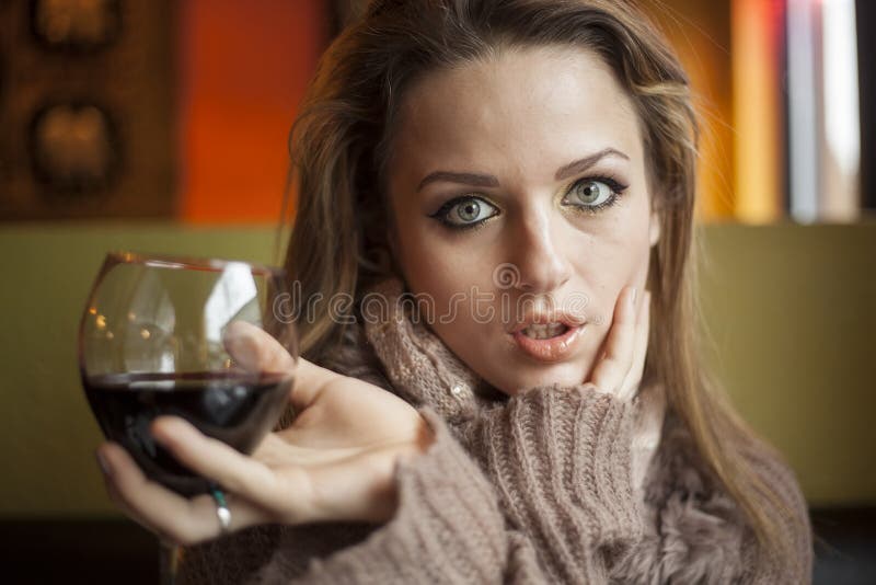 Young Woman with Beautiful Blue Eyes Drinking Red Wine