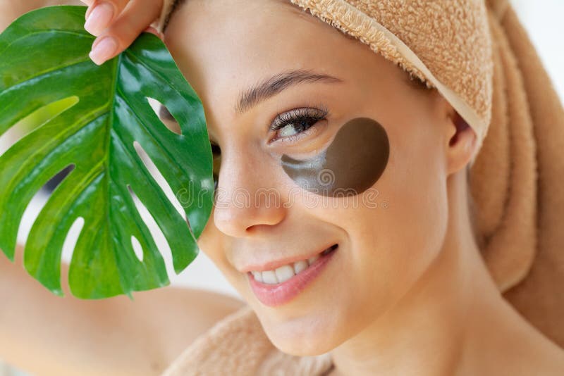 Young Woman with Beautiful Skin Puts Black Patches on Her Face Stock