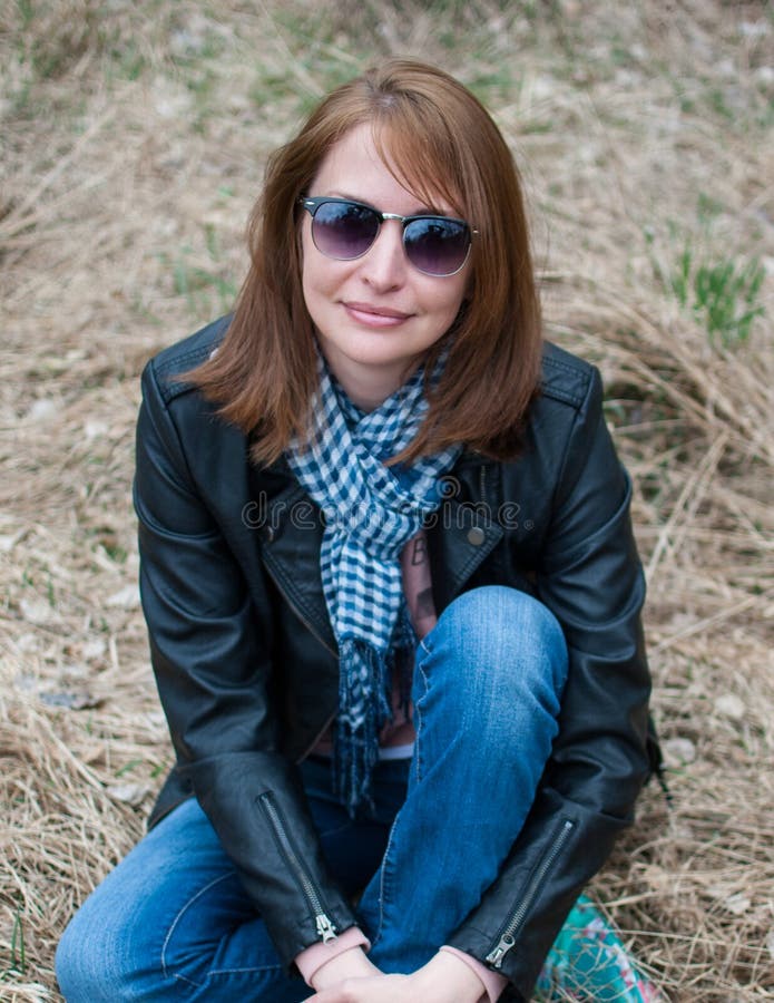 Young Woman in a Black Jacket and Jeans Sitting on the Hay Stock Photo ...