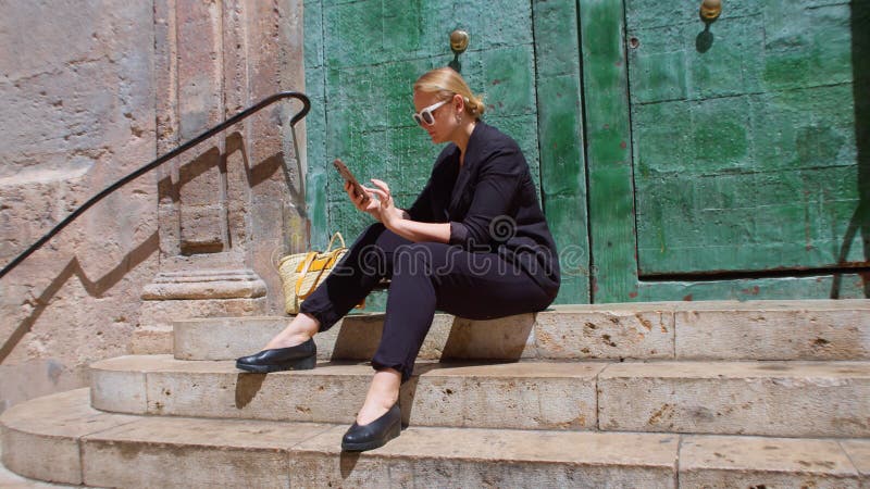 A young woman is sitting on stone steps