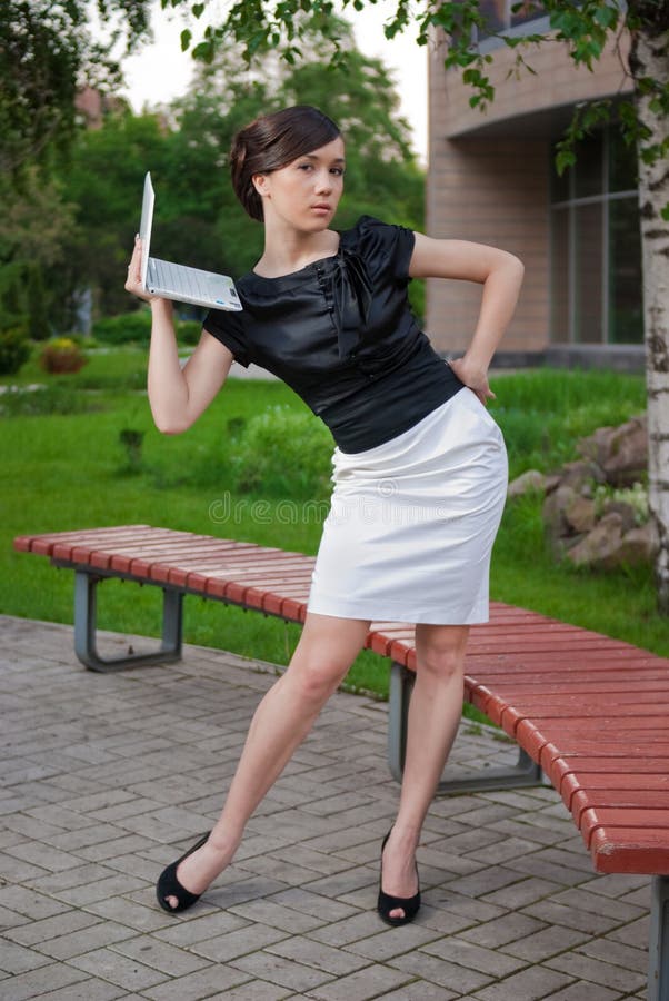 Young woman in black and white suit with laptop