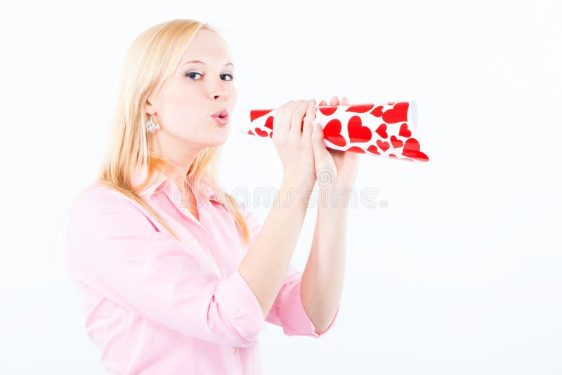 Young woman blowing a love trumpet