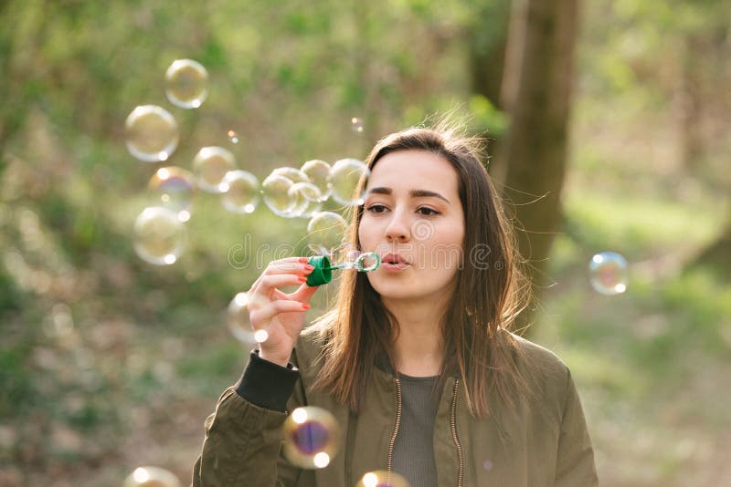 Young woman blowing soap bubbles in the woods royalty free stock photography Young woman blowing soap bubbles in the woods royalty free stock photography