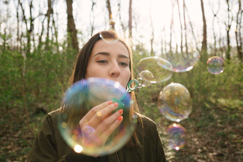 Young woman blowing soap bubbles in the woods stock photography Young woman blowing soap bubbles in the woods stock photography