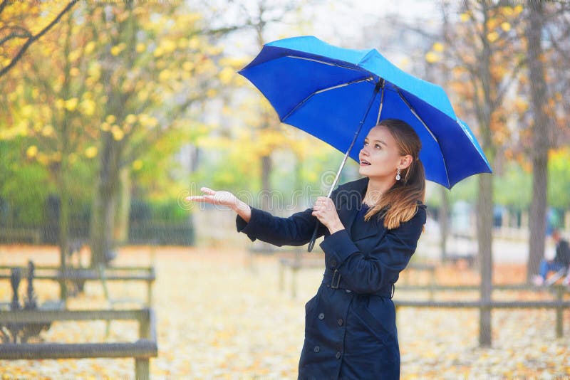 Young woman with blue umbrella in the Luxembourg garden of Paris on a fall or spring rainy day royalty free stock images Young woman with blue umbrella in the Luxembourg garden of Paris on a fall or spring rainy day royalty free stock images