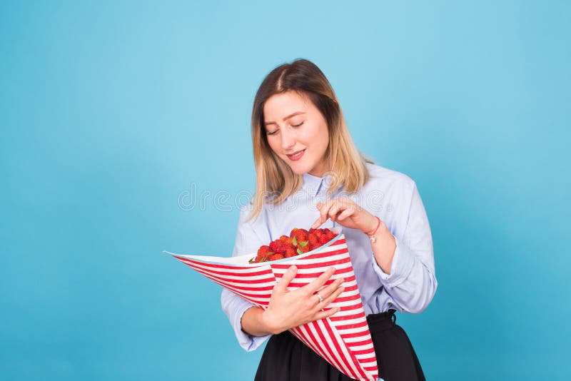 Young woman with a bouquet of strawberry stock images Young woman with a bouquet of strawberry stock images