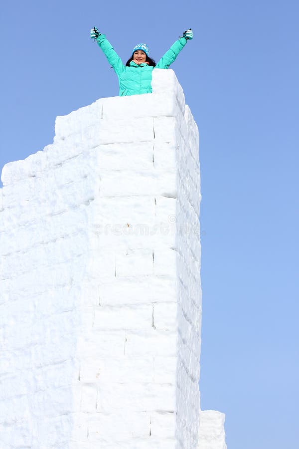 Young woman builds snow castle wall of snow blocks. Winter vacation. Winter and new year holidays stock image Young woman builds snow castle wall of snow blocks. Winter vacation. Winter and new year holidays stock image