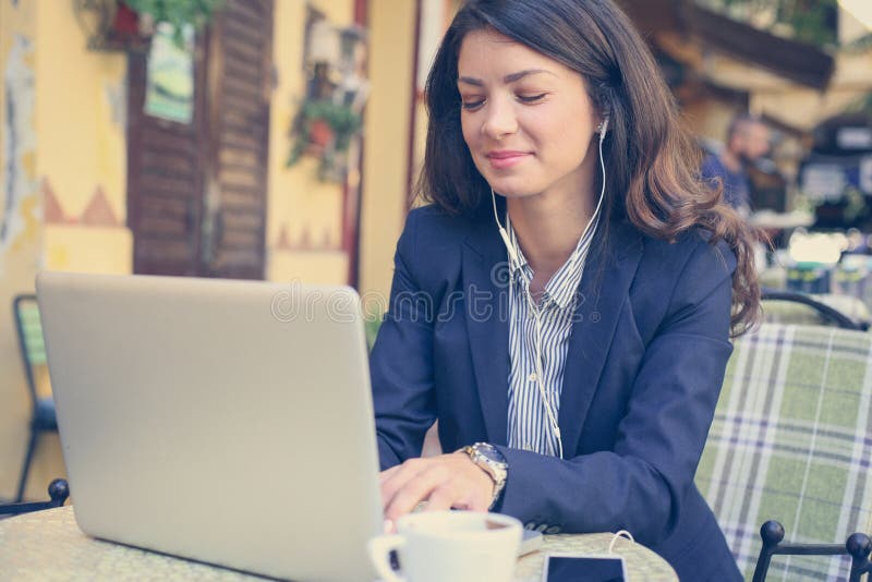 Young woman at cage listening music on laptop. stock photos Young woman at cage listening music on laptop. stock photos