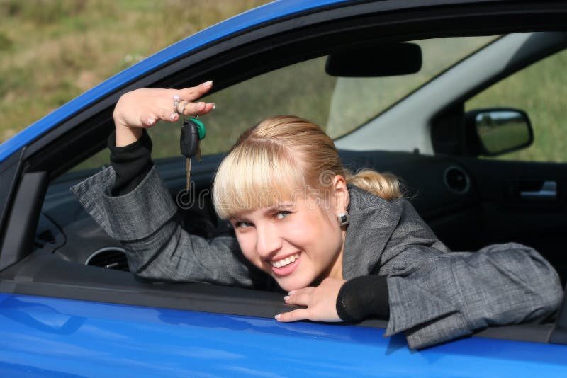 Young woman in car with key