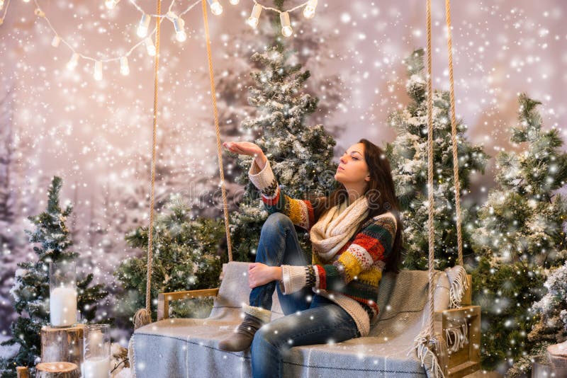 Young Woman Catching a Snowflake while Sitting on a Swing with a Stock ...
