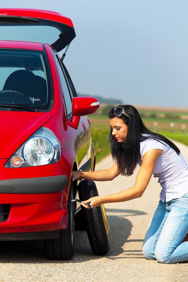 Young Woman Changing Tire stock photo. Image of deflated - 11861208