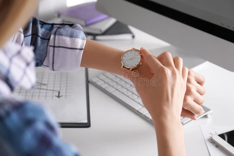 Young woman checking time on her wristwatch stock images Young woman checking time on her wristwatch stock images