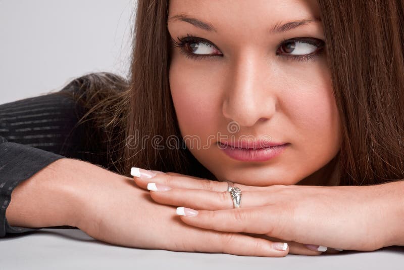 Young woman with chin on hands looking sideways royalty free stock images