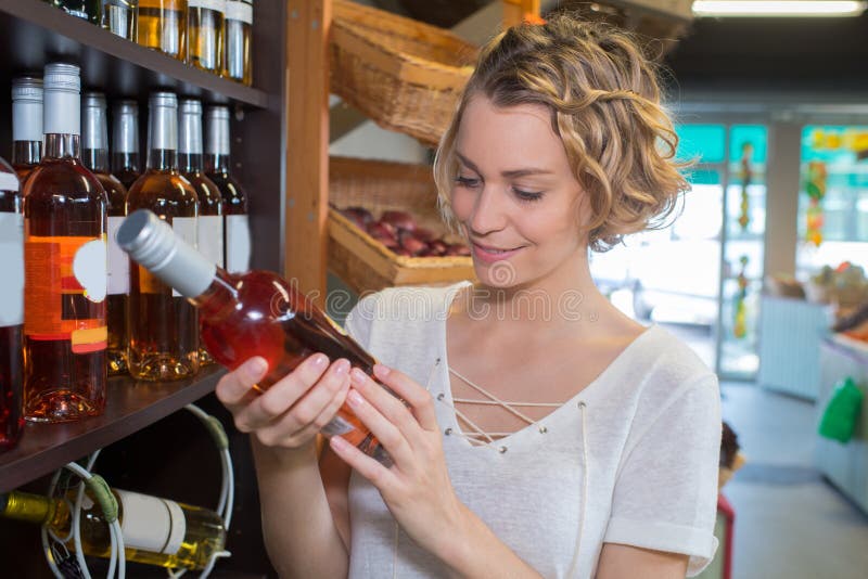 Young woman choosing rose wine in liquor store royalty free stock images Young woman choosing rose wine in liquor store royalty free stock images