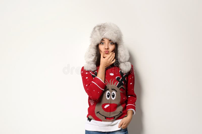 Young woman in Christmas sweater and hat on white background. Bright red hat stock images, royalty-free photos and pictures