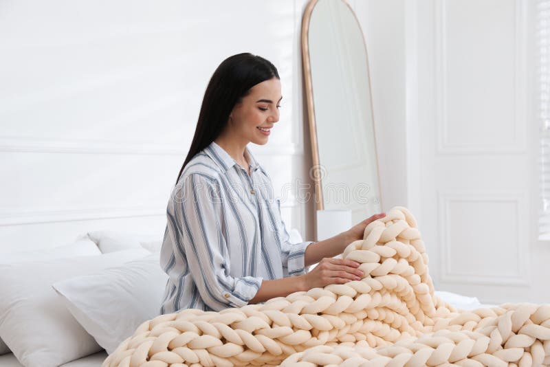 Young Woman with Chunky Knit Blanket on Bed at Home Stock Photo Image