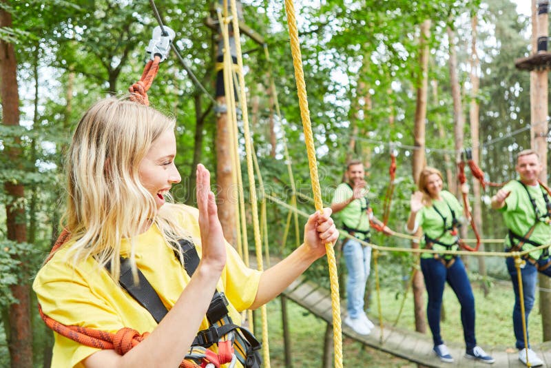 Young woman in climbing course in high wire garden