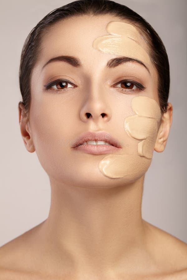 Beautiful face of young woman with cosmetic foundation on a skin. Beauty treatment concept.