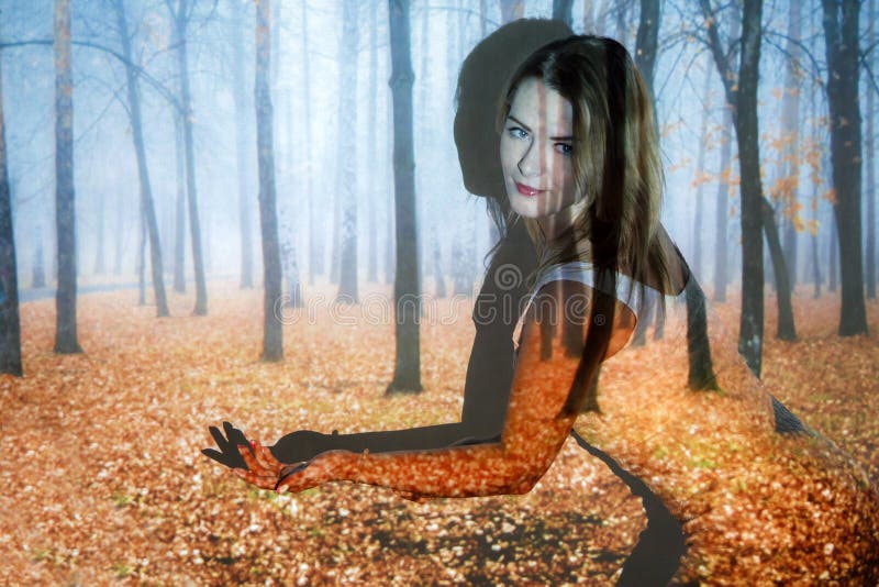 Young woman covered with the picture of the autumn forest stock photo Young woman covered with the picture of the autumn forest stock photo