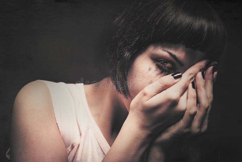 Young woman crying with her hands in her face. Domestic violence. Drained makeup stock photo Young woman crying with her hands in her face. Domestic violence. Drained makeup stock photo