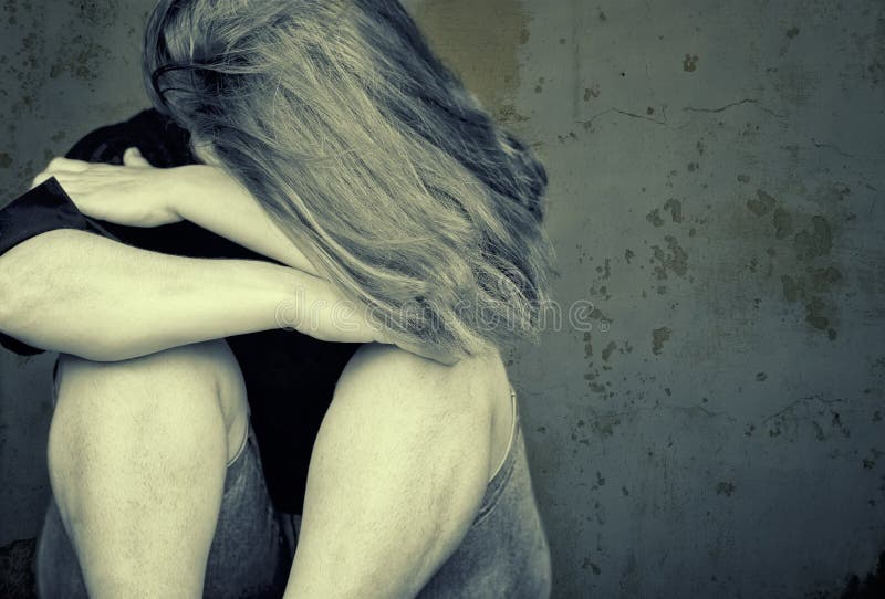 Young woman crying sitting on the floor. 