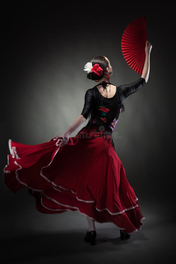 Young woman dancing flamenco on black