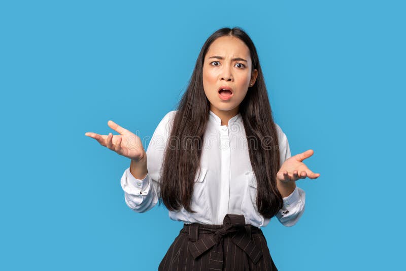 Freestyle. Young woman wearing shirt and skirt standing isolated on blue hands aside speaking outraged