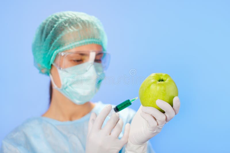 Young woman doctor injecting green apple