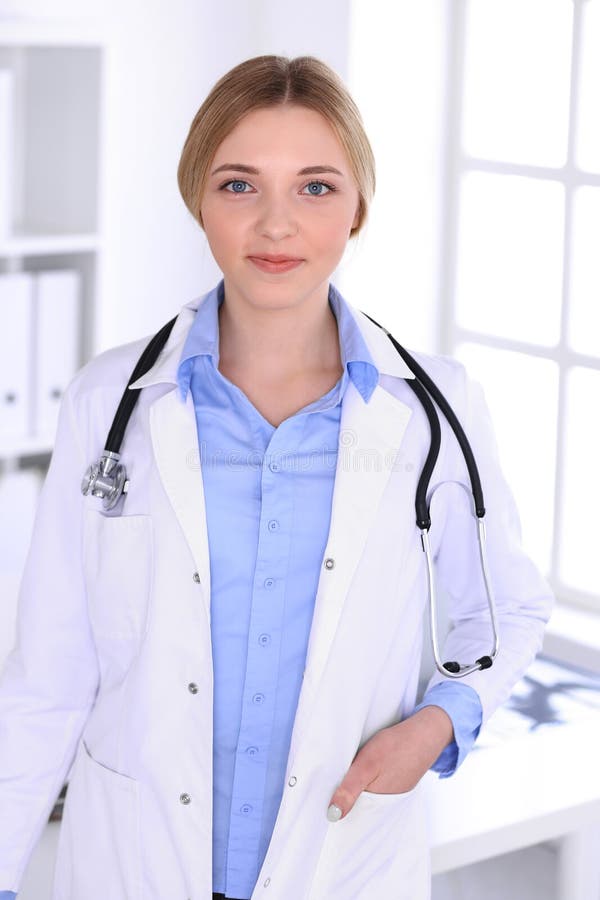 Young Woman Doctor at Work in Hospital Looking at Camera. Blue Colored ...