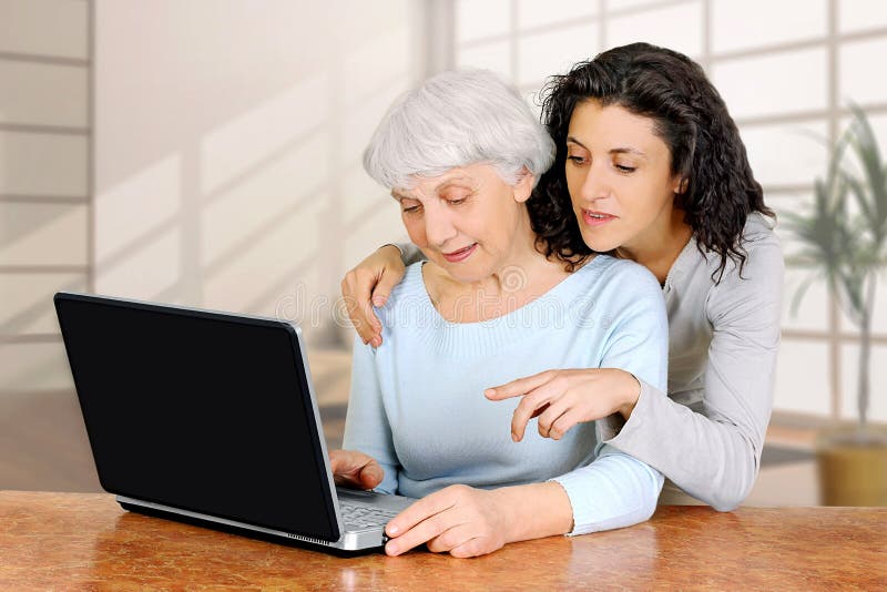 Young woman doctrine teaches daughter of an elderly woman laptop computer stock images Young woman doctrine teaches daughter of an elderly woman laptop computer stock images