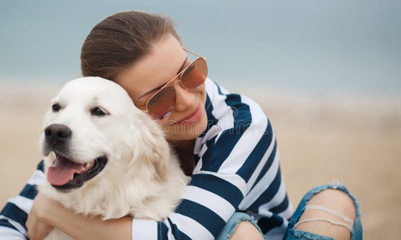 Young woman with a dog on a deserted beach