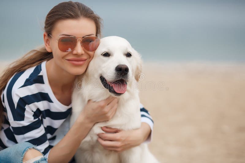 Young woman with a dog on a deserted beach