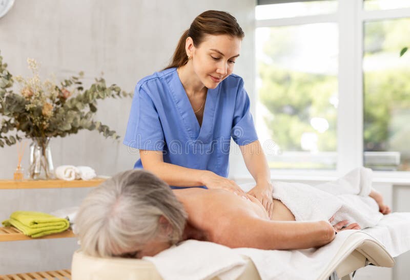 An elderly man getting a back massage, Stock image