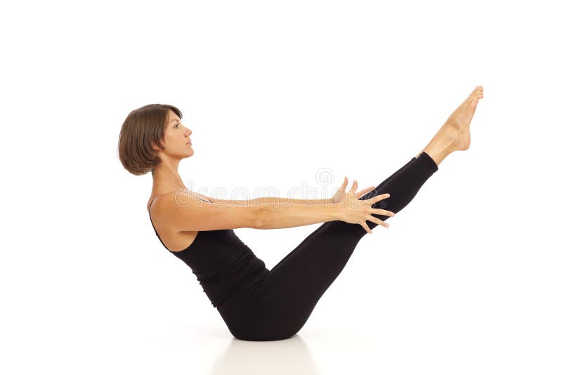 Woman doing boat yoga pose on the beach stock photo (238147