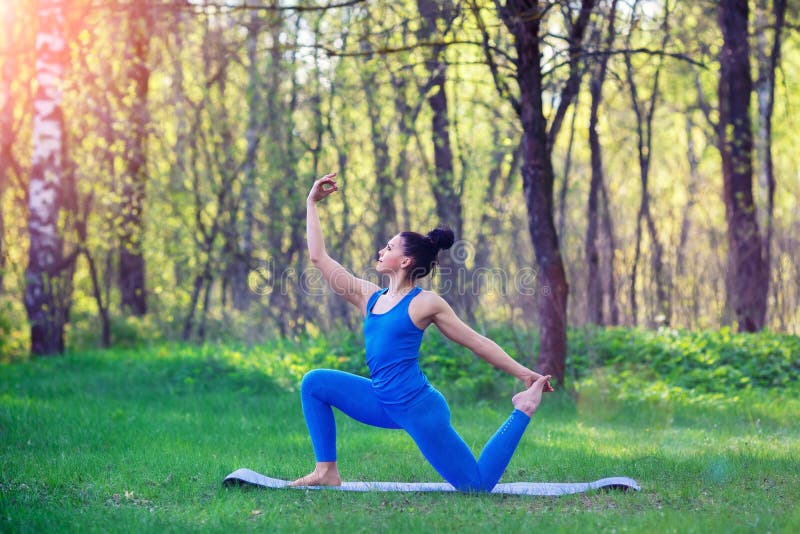 Young woman doing yoga exercises in the summer city park. Health lifestyle concept. royalty free stock photos Young woman doing yoga exercises in the summer city park. Health lifestyle concept. royalty free stock photos