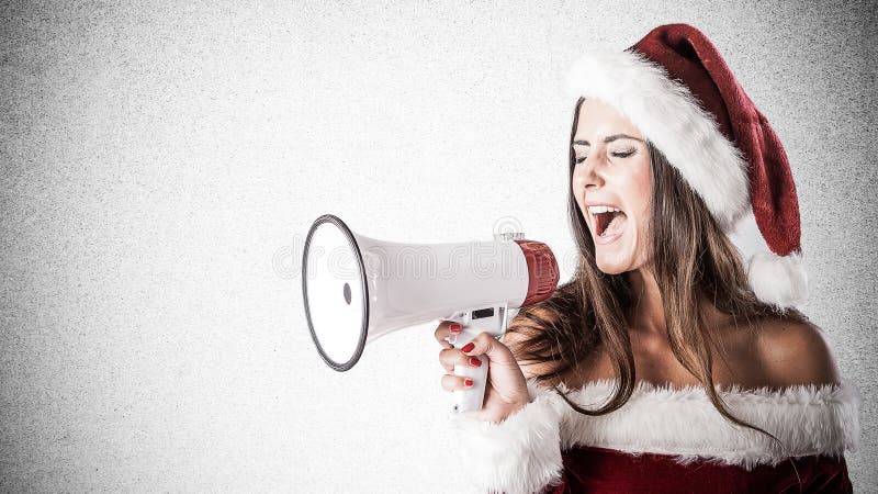 Young woman dressed as Santa Claus shouting into a megaphone stock photography