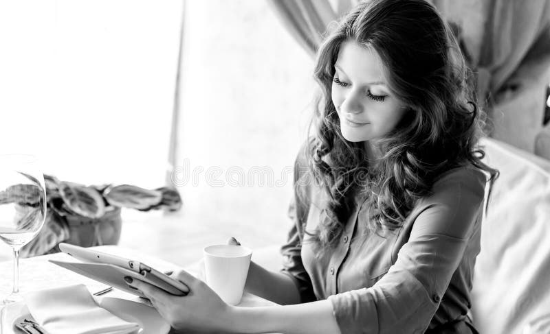Young woman drinking coffee in a cafe. Black and white photo. stock photography