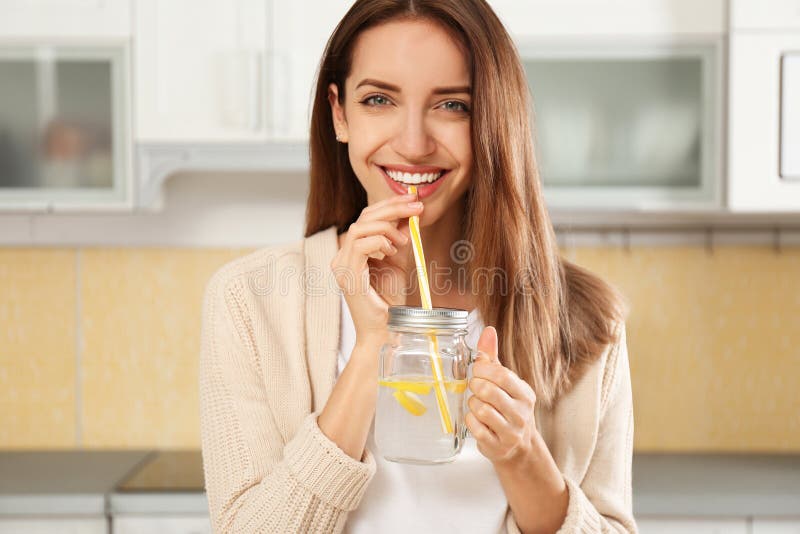 Young woman drinking lemon water