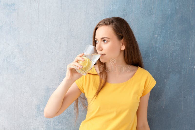Young woman drinking lemon water