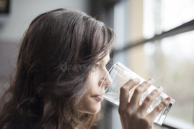 Young Woman Drinking a Pint Glass of Ice Water royalty free stock photography Young Woman Drinking a Pint Glass of Ice Water royalty free stock photography