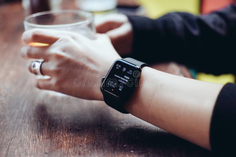 Young woman drinking with smart watch at bar